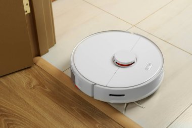 Beyaz zeminde modern robotik elektrikli süpürge.