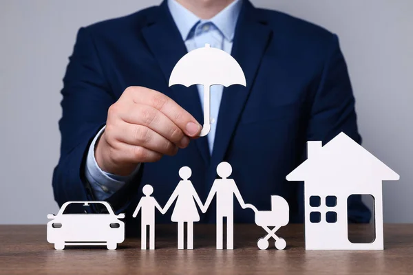 Man Holding Figure Umbrella Family Wooden Table Closeup Insurance Concept — Stock Photo, Image