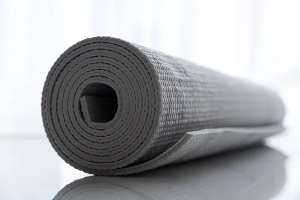 stock image Rolled karemat or fitness mat on tiled floor, closeup