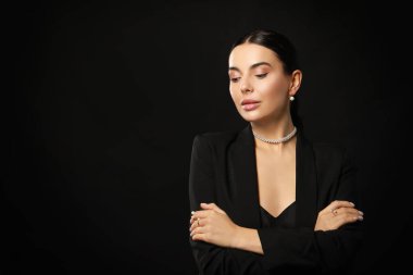 Siyah arka planda zarif inci takıları olan genç bir kadın, metin için yer var.
