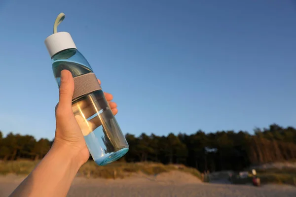 Donna Possesso Bottiglia Vetro Con Acqua Contro Cielo Blu Primo — Foto Stock