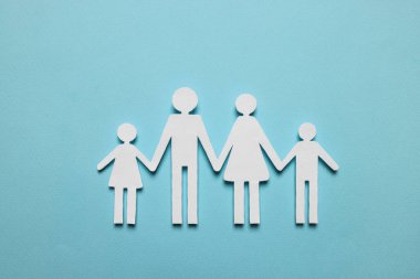 Kağıt aile figürleri açık mavi arka planda, üst manzara. Sigorta konsepti