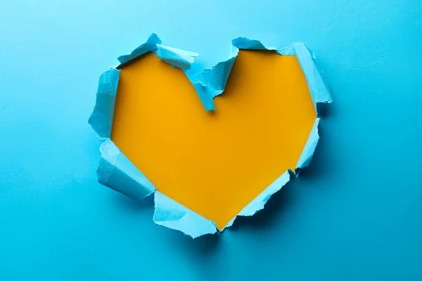Furo Forma Coração Rasgado Papel Azul Claro Fundo Amarelo — Fotografia de Stock