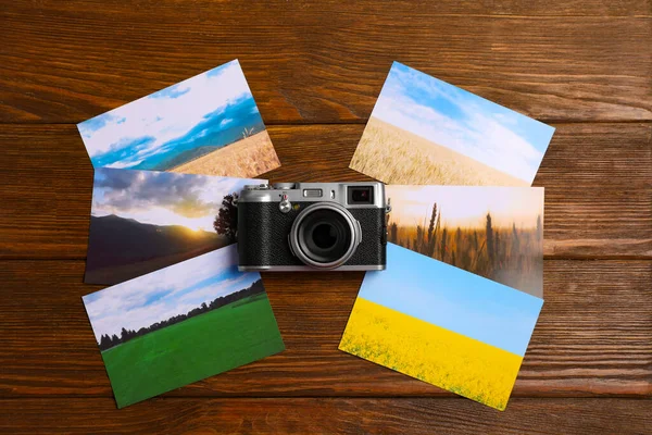 stock image Vintage photo camera and beautiful printed pictures on wooden table, flat lay. Creative hobby