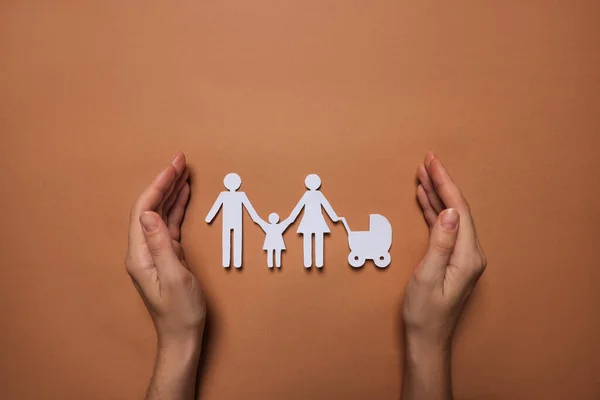 Frau Schützt Familienfiguren Aus Papier Auf Braunem Hintergrund Draufsicht Versicherungskonzept — Stockfoto