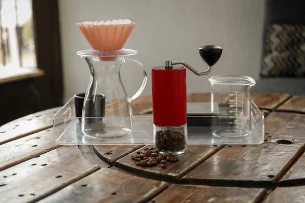 豆と手動コーヒーグラインダー カフェで木製のテーブルの上にガラスのジャグと波のドリッパー — ストック写真