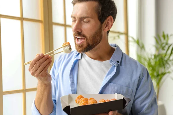Homme Mangeant Des Rouleaux Sushi Savoureux Tenant Boîte Dans Chambre — Photo