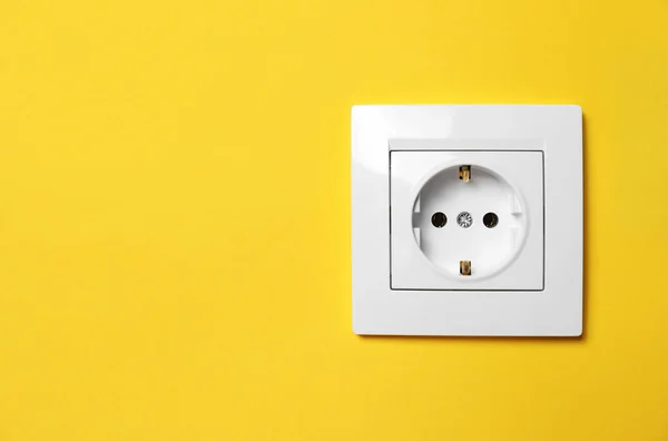 stock image Power socket on yellow wall, space for text. Electrical supply