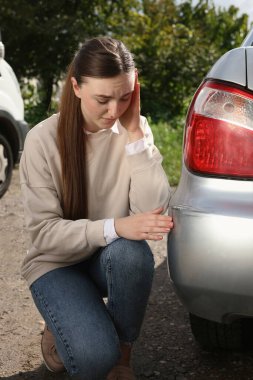 Arabanın yanında, açık havada çizik olan stresli kadın.