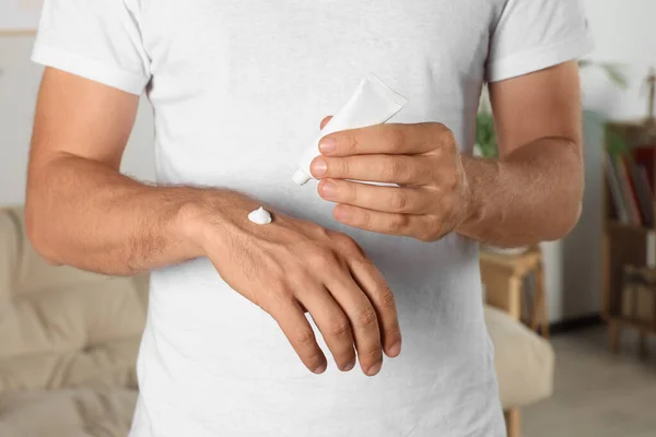 stock image Man applying cream from tube onto hand at home, closeup