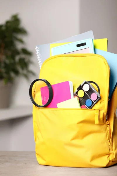 Gelber Rucksack Mit Verschiedenen Schulmaterialien Auf Tisch Drinnen — Stockfoto