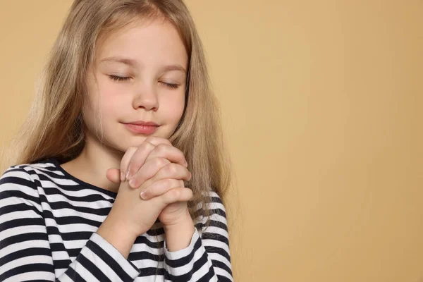 Дівчина Закрученими Руками Молиться Бежевому Фоні Простір Тексту — стокове фото