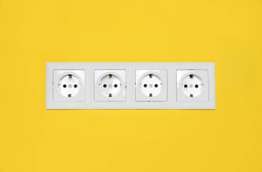 Sarı duvardaki prizler. Elektrik arzı