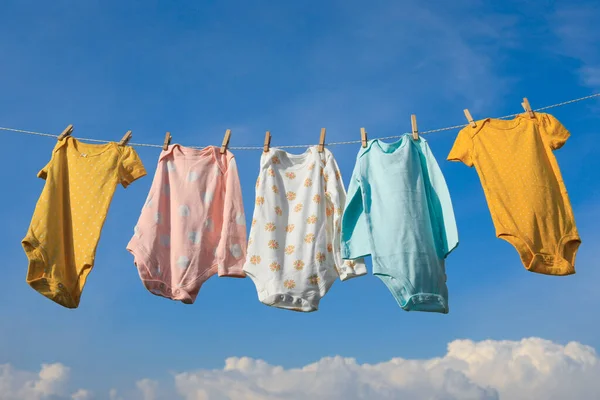干净的小宝宝们挂在晾衣绳上与天空相对 干衣服 — 图库照片