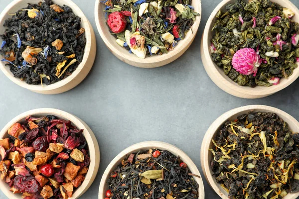 Açık Gri Masadaki Ahşap Kaselerde Farklı Türde Kuru Bitkisel Çay — Stok fotoğraf