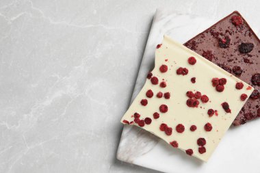 Açık mermer masada dondurulmuş meyveleri olan farklı çikolatalar, üst manzara. Metin için boşluk