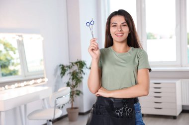 Güzellik salonunda profesyonel makasla mutlu bir kuaförün portresi. Metin için boşluk