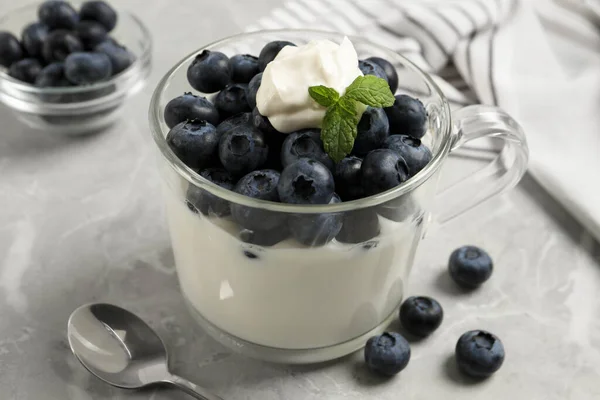 Delicious Yogurt Blueberries Served Grey Marble Table Closeup — Stock Photo, Image