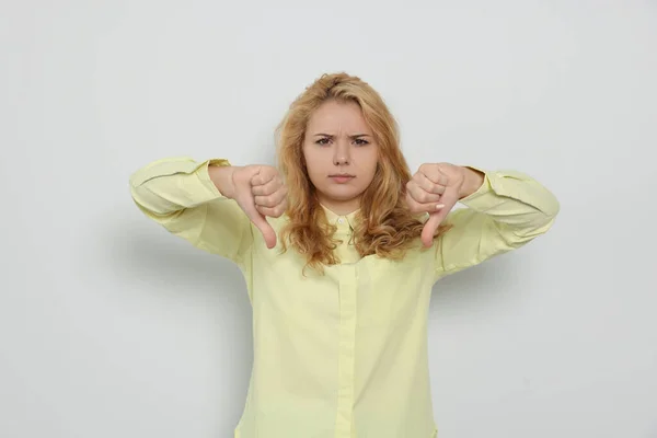 Δυσαρεστημένη Νεαρή Γυναίκα Που Δείχνει Τους Αντίχειρες Κάτω Στο Λευκό — Φωτογραφία Αρχείου