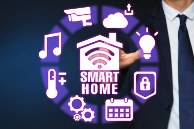 Koyu mavi arkaplanda Smart Home arayüzü kullanan adam, kapat