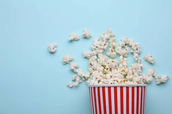 Umgekippter Pappbecher Mit Leckerem Popcorn Auf Hellblauem Hintergrund Flache Lage — Stockfoto