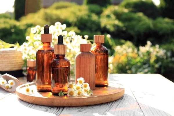 Bottles Essential Oil Flowers White Wooden Table Outdoors Space Text — Stock Photo, Image