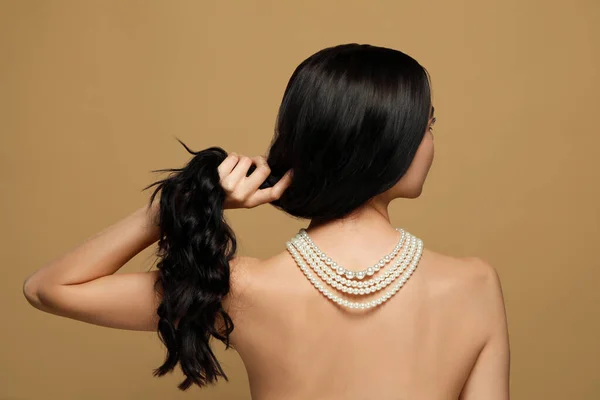 Młoda Kobieta Eleganckim Perłowym Naszyjniku Brązowym Tle Widok Tyłu — Zdjęcie stockowe