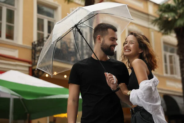 Şemsiyeli Genç Çift Şehir Sokaklarında Yağmurun Altında Eğleniyor — Stok fotoğraf