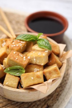 Lezzetli kızarmış tofu, fesleğen ve susam tohumlarıyla dolu bir kase.