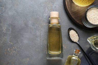 Taze susam yağı ve tohumlar gri masada, düz yerde. Metin için boşluk