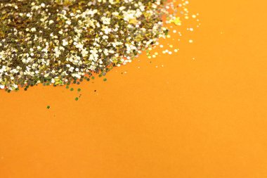 Shiny bright golden glitter on pale coral background. Space for text