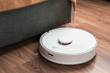 Robotik süpürge, ahşap zeminde, kapalı alanda.