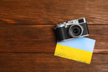 Klasik fotoğraf makinesi ve ahşap masanın üzerinde basılmış güzel bir resim. Düz yerde, mesaj için yer var. Yaratıcı hobi