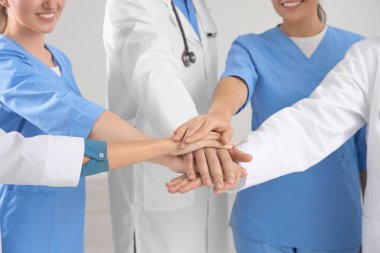 Tıp doktorlarından oluşan bir ekip ellerini içeride birleştirip, yakınlaştırıyor.