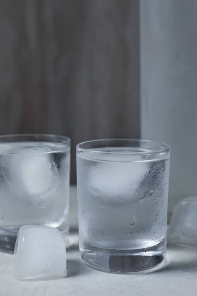 Vasos Vodka Con Cubitos Hielo Sobre Mesa Gris Claro —  Fotos de Stock