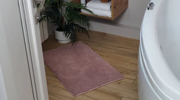 stock image Soft bath mat on wooden floor in bathroom