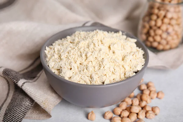 stock image Chickpea flour in bowl and seeds on light grey table, closeup