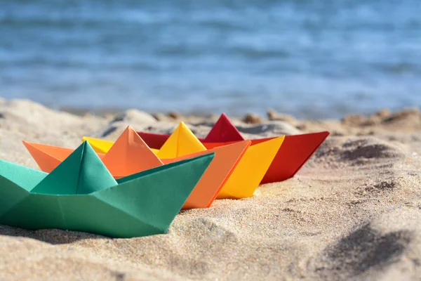 Many paper boats near sea on sunny day. Space for text