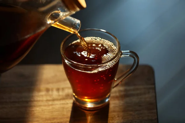 Ρίχνει Νόστιμο Τσάι Γυάλινο Κύπελλο Στο Ξύλινο Τραπέζι Closeup — Φωτογραφία Αρχείου