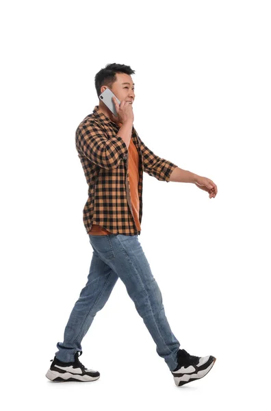 Homem Falando Smartphone Enquanto Caminha Contra Fundo Branco — Fotografia de Stock