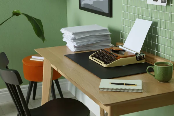薄い緑の壁の近くの木製のテーブルの上にタイプライター 紙やムードボードのスタック 作家の職場 — ストック写真
