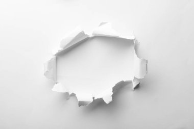 Hole in white paper on light background clipart