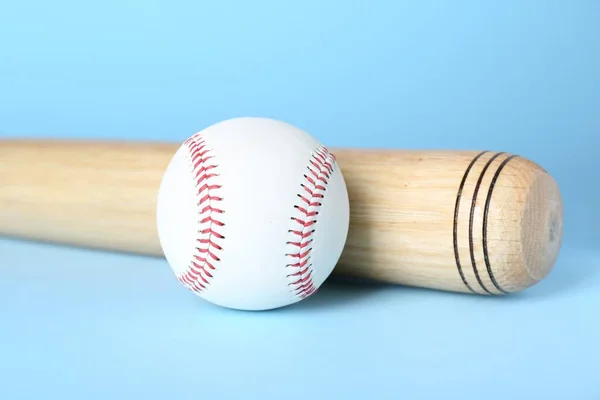 木制棒球棒和浅蓝色背景的球 体育设备 — 图库照片