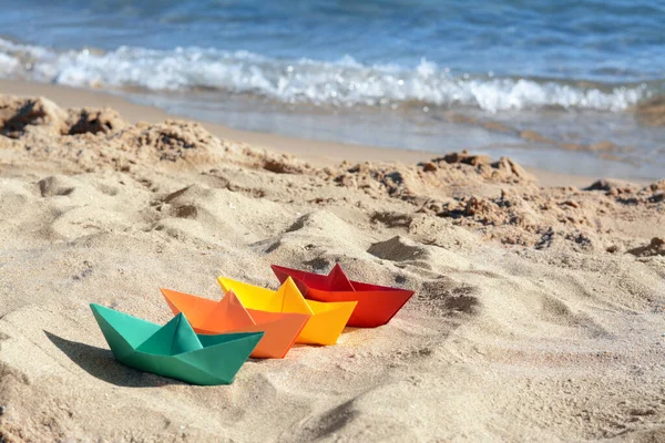 Many paper boats near sea on sunny day, space for text