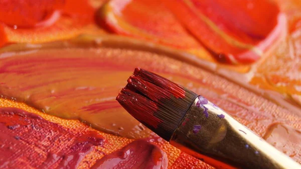 stock image Brush on artist's palette with mixed paints, closeup