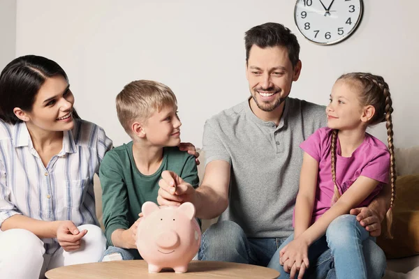 Gelukkige Familie Munt Ingebruikneming Piggy Bank Thuis — Stockfoto