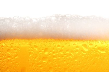 Glass of tasty cold beer with foam and condensation drops on white background, closeup