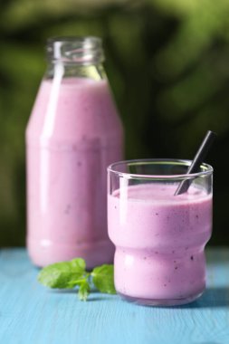 Lezzetli böğürtlenli smoothie ve nane açık mavi ahşap masa, yakın plan