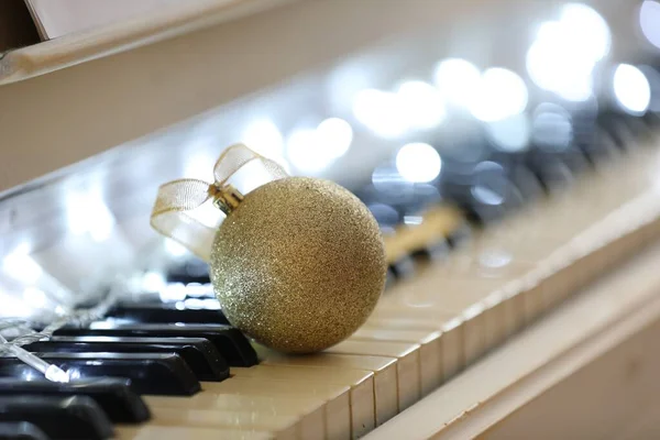 Schöne Goldene Christbaumkugel Und Elfenlichter Auf Klaviertasten Nahaufnahme Weihnachtsmusik — Stockfoto