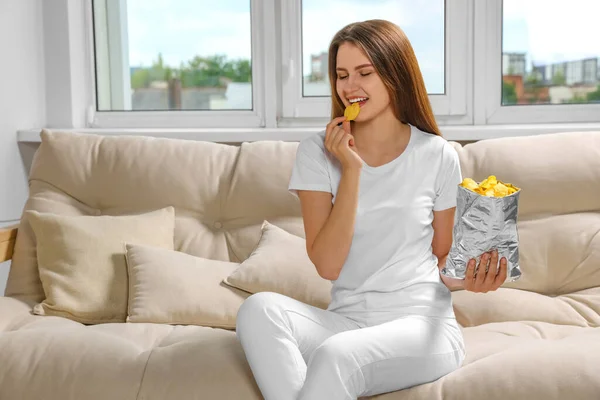 Pretty Young Woman Eating Tasty Potato Chips Sofa Home — Stock Photo, Image